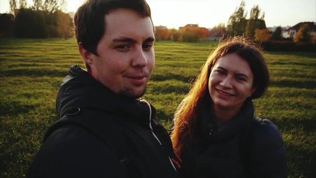 Young happy man and woman making selfie outdoor strong back light slow motion HD
