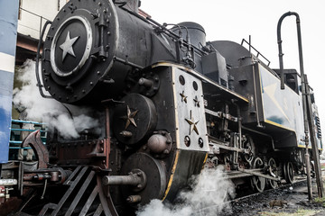 Old steam engine locomotive train and smoke at Ooty trains station, Nilgiri Mountain Railway, India 