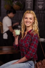 Smiling blonde drinking a beverage