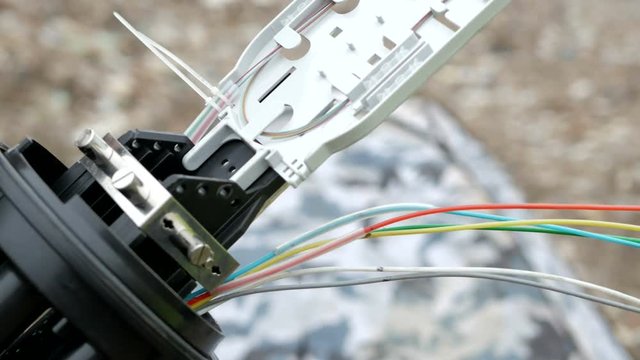 Technicians are installing optic fiber with cable ties.