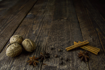 walnut anise cinnamon sticks and pepper on a wooden background