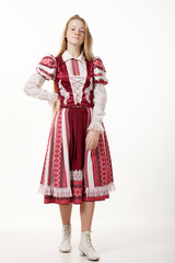 Young beautiful redhead folk dancer woman with gorgeous long hair in traditional authentic folk costume posing isolated on white background