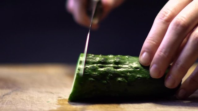 Woman Cutting Cucumber in Kitchen