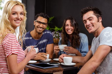 Smiling friends enjoying coffee together