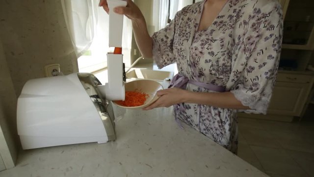 Woman blending carrots in home kitchen