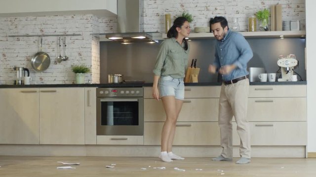 Young Couple Quarrels in the Kitchen. Girl Had Enough and She Breaks the Plate. Man Screams in Frustration and Angrily Gesticulates. Slow Motion. Shot on RED Cinema Camera in 4K (UHD).