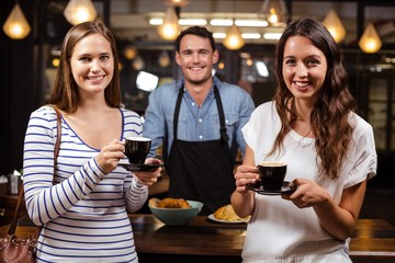 Portrait of smiling women with coffee and barista
