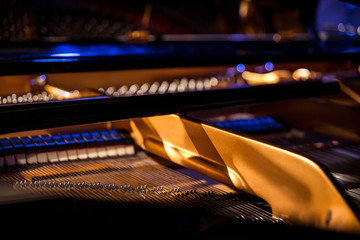 Pattern of hammers and strings inside piano, close up. One hummer in action while key is pressed....