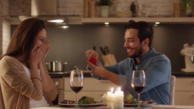 While Having Romantic Dinner in the Kitchen. Young Man Proposes to his Beautiful Girfriend. Gives Her a Ring.  Shot on RED Cinema Camera in 4K (UHD).