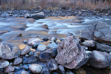 Fototapeta na wymiar Icy water flows over rocks in the Poudre River in Colorado