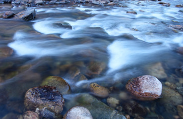 Icy water flows over rocks in the Poudre River in Colorado