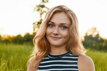 A close-up of a happy pretty girl with wrinkles and dimple on her face. A light-haired girl looking...
