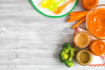 cooking mashed carrots for baby on wooden background top view