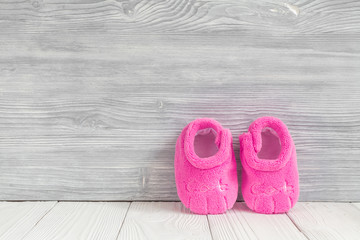 pink booties on wooden background