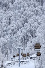 Cableway cabin lift on the winter forest background beautiful vertical scenery
