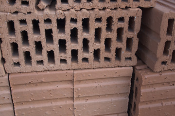 Bricks of clay, light red, piled up for construction