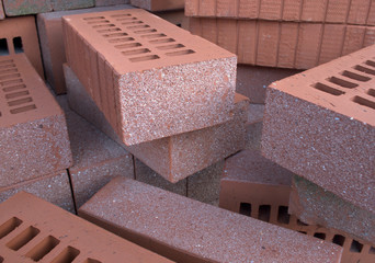 Burned clay construction bricks pile, perspective