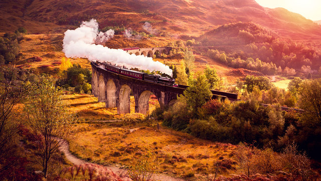 Eine Dampflockomotive fährt über das Glenfiann Viaduct