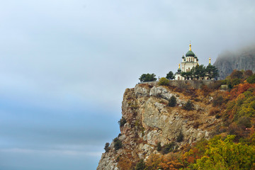 Church on the steep slope of the fall in the mountains. Landscape