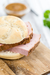 Portion of German Leberkaese on wooden background (selective foc