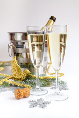 glasses of champagne and Christmas ornaments on white background