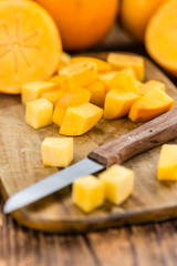 Wooden table with Kaki fruits (selective focus)