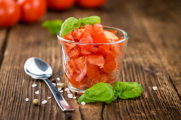 Tomatoes (diced) on wooden background (selective focus)