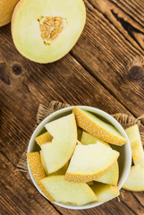 Portion of Honeydew Melon on wooden background (selective focus)