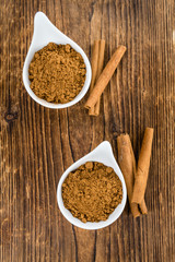 Portion of Cinnamon Powder on wooden background (selective focus