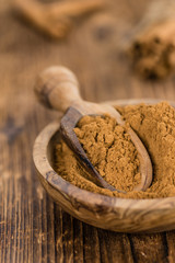 Portion of Cinnamon Powder on wooden background (selective focus