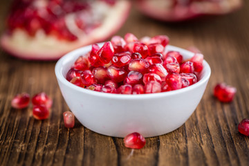 Pomegranate seeds on wooden background (selective focus)
