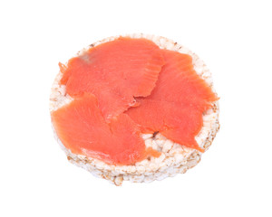 Smoked wild pacific sockeye salmon on organic brown rice cake isolated on white background