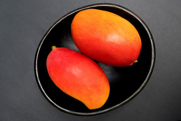 Mangos - Frutas exóticas tropicales sobre fondo negro - fotografía de estudio