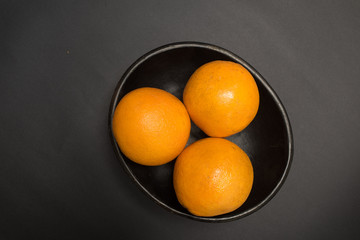 Naranjas - Frutas exóticas tropicales sobre fondo negro - fotografía de estudio