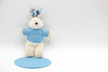 Rabbit soft toy in blue shirt on white background
