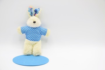 Rabbit soft toy in blue shirt on white background