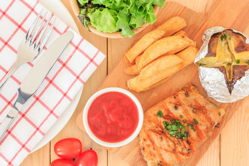 Grilled meat steak serve with tomato sauce, Mashed Potatoes, french fries and vegetable salad, isolated on wooden background, Closed up