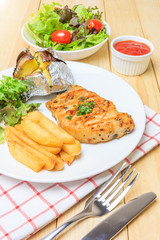 Grilled meat steak serve with tomato sauce, Mashed Potatoes, french fries and vegetable salad, isolated on wooden background, Closed up