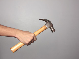 Man holding hammer on gray background