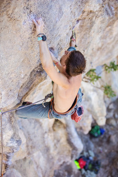 Male rock climber on a face of a cliff, view from above