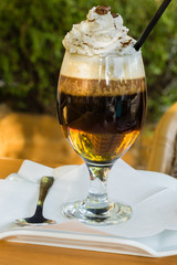 Irish coffe served in outdoor cafe with reflection of everything around