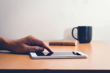 Man with modern mobile phone in hands touching on a blank screen