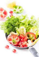 Fresh salad vegetables in pan isolated on white background