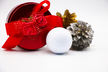 Present for golfer, golf ball , red gift box with pine cone on white background
