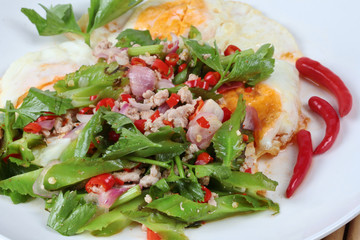 Thai food,Spicy wing bean with pork topped fried egg.