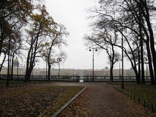 Fototapeta na wymiar Park at Vasilievsky island Saint-Petersburg, Russia with openwork fence at gloomy day