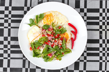 Thai food,Spicy wing bean with pork topped fried egg.