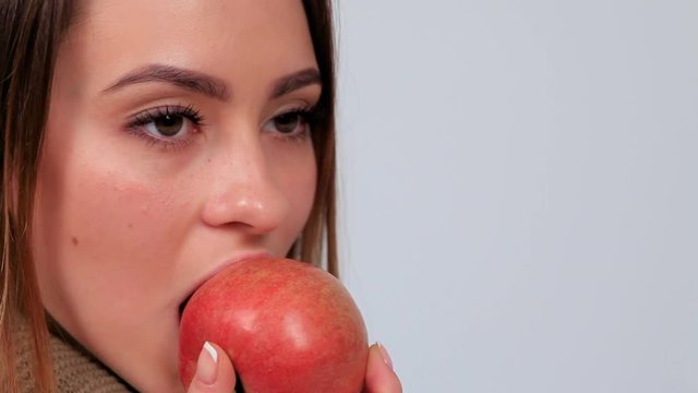 Beautiful young woman eating apple
