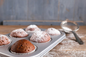 Chocolate muffins in a metal baking dish.