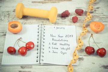 Vintage photo, New year resolutions written in notebook on old board